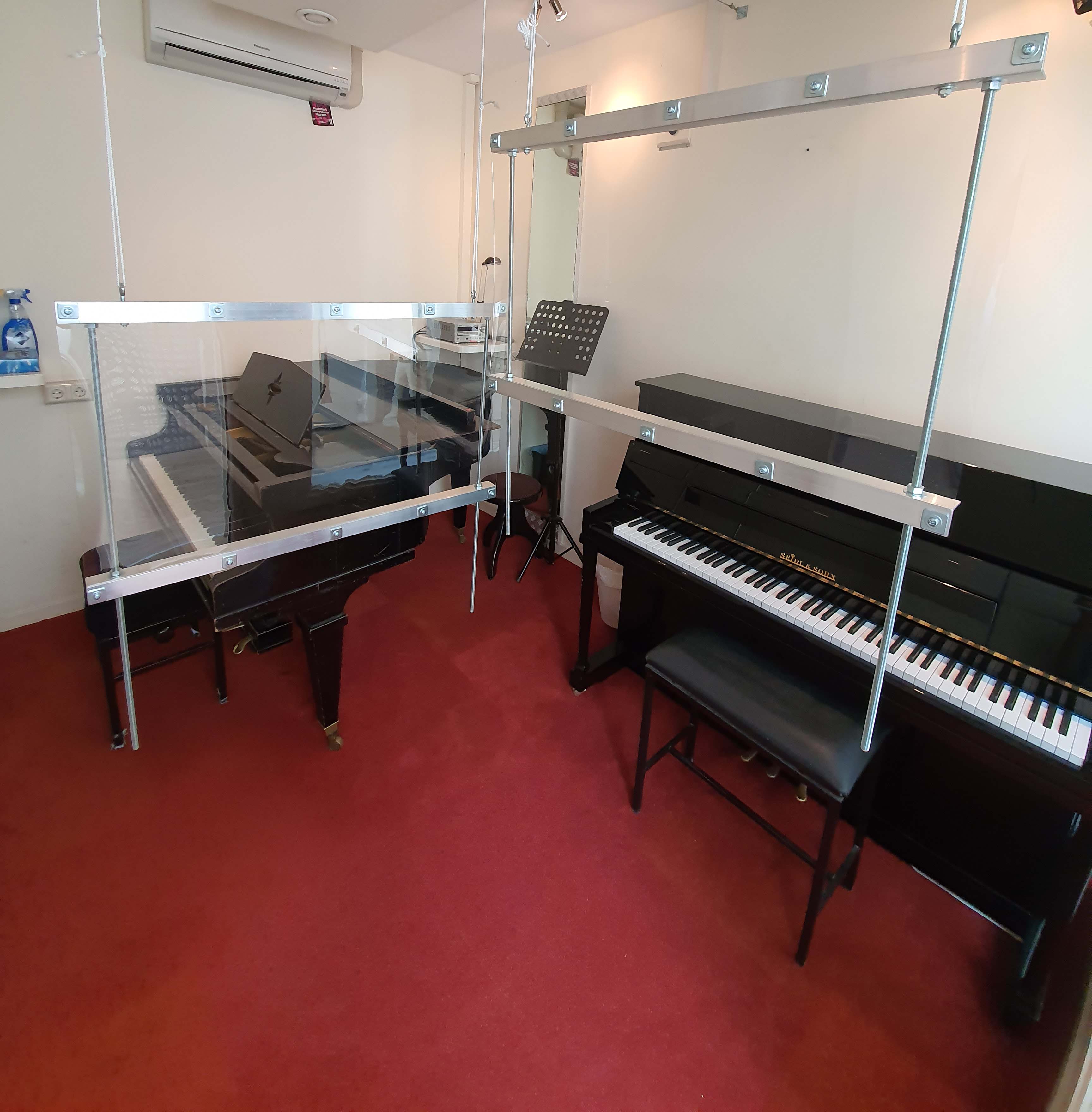 Pianolokaal met schermen bij Tune Up Muziekpunt
